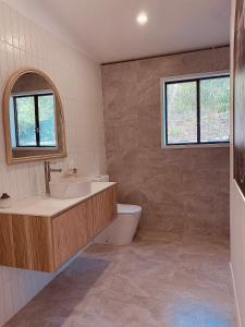 a bathroom with a tub and a sink and a toilet at Private Guest House in Wongawallan