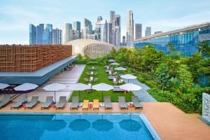 uma piscina com cadeiras e guarda-sóis e um horizonte da cidade em PARKROYAL COLLECTION Marina Bay, Singapore em Singapura