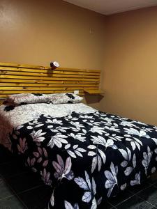 a bedroom with a bed with a black and white blanket at Hotel Gran Riviera in Cartagena