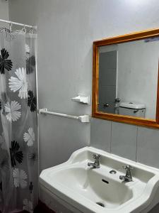 La salle de bains est pourvue d'un lavabo blanc et d'un miroir. dans l'établissement Hotel Gran Riviera, à Carthagène