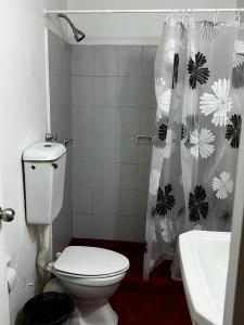 y baño con aseo y cortina de ducha. en Hotel Gran Riviera, en Cartagena