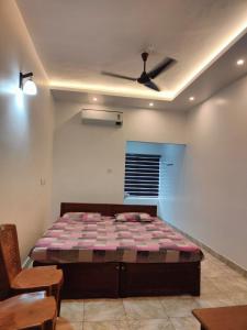 a bedroom with a bed and a ceiling fan at Thekkumpuram Tourist Home in Malappuram