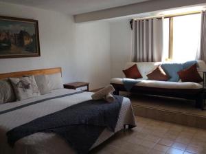 sypialnia z łóżkiem i kanapą w obiekcie Casa Arena w mieście Casa Blanca La Corregidora