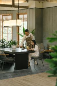 een man en een vrouw die eten klaarmaken in een keuken bij Novus Giri Resort & Spa in Puncak
