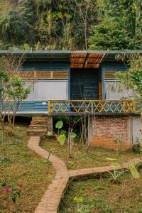 una casa con una puerta azul y un camino de ladrillo en Stella Mộc Châu Homestay, en Mộc Châu