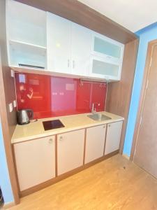 a small kitchen with white cabinets and a sink at Luxury APEC MANDALA MŨI NÉ SG HAPPY HOUSE in Ấp Thiẹn Ái