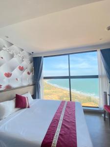 een slaapkamer met een bed en een groot raam bij Luxury APEC MANDALA MŨI NÉ SG HAPPY HOUSE in Ấp Thiẹn Ái