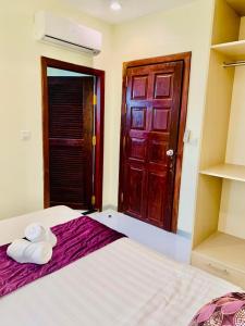 een slaapkamer met een bed met twee handdoeken erop bij White Residence Hotel & Apartment in Phnom Penh