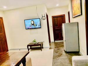 a living room with a refrigerator and a table at White Residence Hotel & Apartment in Phnom Penh