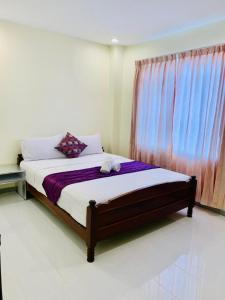 a bedroom with a large bed with a window at White Residence Hotel & Apartment in Phnom Penh