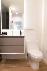 uma casa de banho branca com um WC e um lavatório em El Depita loft Polanco em Cidade do México