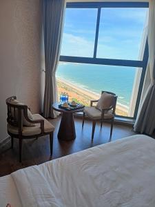 a hotel room with a bed and a view of the ocean at Luxury APEC MANDALA MŨI NÉ SG HAPPY HOUSE in Ấp Thiẹn Ái