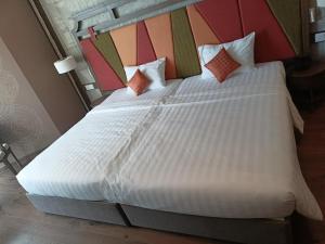 een slaapkamer met een groot bed met witte lakens en kussens bij Luxury APEC MANDALA MŨI NÉ SG HAPPY HOUSE in Ấp Thiẹn Ái