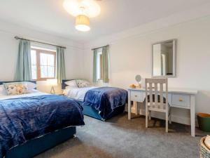 1 dormitorio con 2 camas, escritorio y espejo en 5 bed in West Linton 81467 en West Linton