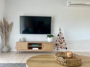 Μια τηλεόραση ή/και κέντρο ψυχαγωγίας στο Cosy Beach House - Near Hot Springs.