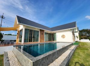 a house with a swimming pool in front of it at Ada Pool Villa Khaoyai in Pong Talong