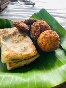 a plate of food on a green banana leaf at The Eco-Lodge 더 에코-롲지 in Maho