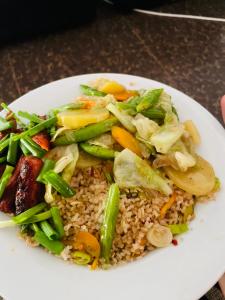 un plato blanco de comida con arroz y verduras en The Eco-Lodge 더 에코-롲지 en Maho