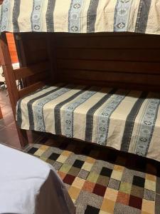 een bed met een gestreept dekbed in een kamer bij Chalé aconchegante in Itu