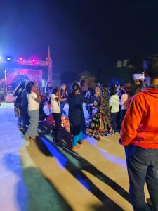 a group of people dancing on the beach at night at Awar Desert Safari in Jaisalmer