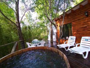 a pool with chairs and a table on a deck at CONCEPTO GLAMPING - DOMOS CONGUILLIO in Melipeuco