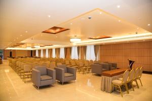 a conference room with chairs and a table and a podium at Hotel Grand Serene, Mysore in Mysore