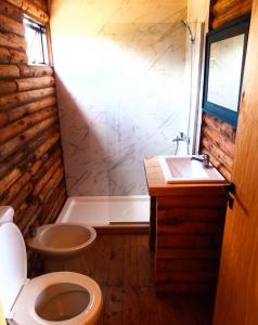 a bathroom with a toilet and a sink at Complejo de Cabañas Pura Vida in Balneario Reta