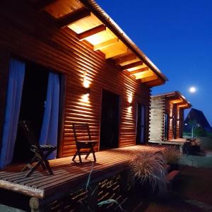 una terraza de madera con una silla en una casa en Complejo de Cabañas Pura Vida, en Balneario Reta