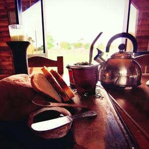 un tavolo in legno con bollitore per tè e pane di Complejo de Cabañas Pura Vida a Balneario Reta