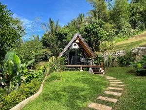 a small house in the middle of a yard at Jinjer Resort in Cavinti