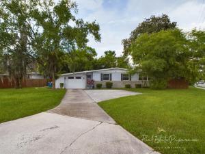 a house with a driveway in a yard at The POSH FLEX Renovated Mid Century Modern 3BR 2B Heart of The City 3 Mins to JU 5 Mins to Downtown 10 Mins Jax Cruise 15 Mins to Beach 15 Mins to MAYO Clinic in Jacksonville