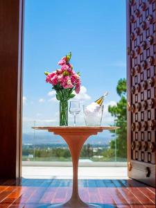 a table with a vase of flowers and two glasses at CASONA LA MARQUEZA - Hotel Boutique in Tinquipaya