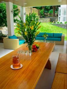 een houten tafel met een vaas met bloemen erop bij CASONA LA MARQUEZA - Hotel Boutique in Tinquipaya