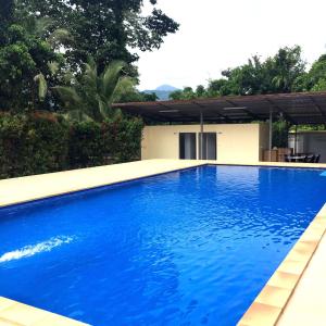 a large blue swimming pool in front of a house at Baan Suan Khun Yaiy in Ban Wang Takhrai