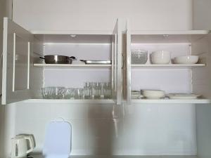 a kitchen with a refrigerator filled with dishes at Star house in Ko Lanta