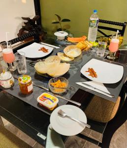 a table with plates of food and drinks on it at Rani Suite and Cabin in Kandy