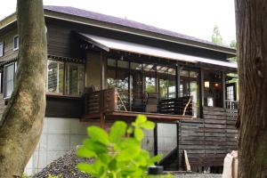 a house with a large deck with glass windows at POND CABIN Myoko - Vacation STAY 15921 in Myoko