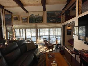 a living room with a couch and a large window at POND CABIN Myoko - Vacation STAY 15921 in Myoko