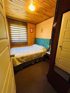 um pequeno quarto com uma cama num quarto em Cabaña Puerto Octay em Puerto Octay
