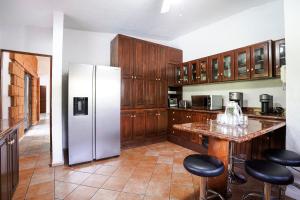 a kitchen with a refrigerator and some bar stools at Cozy family house I Pool & Bar l Cuernavaca in Cuernavaca