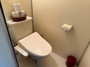 a small bathroom with a toilet with a remote control at Mt.Fuji Rising Sun Inn in Fuji