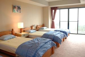 a bedroom with three beds in a room at Mt.Fuji Rising Sun Inn in Fuji