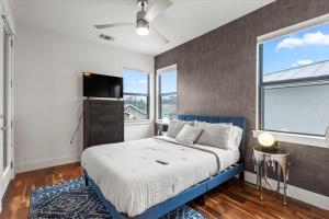 een slaapkamer met een blauw bed en een groot raam bij 4 Bedroom-Downtown-Rooftop W Views & Walkable in Austin