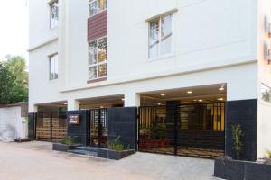 a white building with a black and white facade at Sanctum Suites Whitefield Bangalore in Bangalore