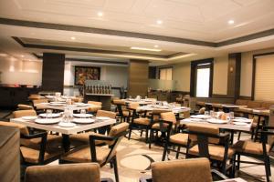 a restaurant with tables and chairs in a room at The Ambassador Hotel Pune in Pune