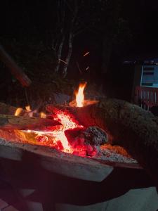 - un grand foyer extérieur avec flammes la nuit dans l'établissement Sri Sai Nature Stay, à Madikeri