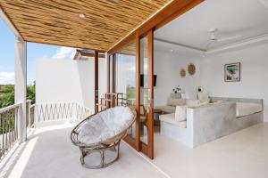 a living room with a chair and a couch at Pagi Villas by Hombali in Mengwi
