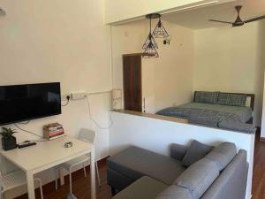 a living room with a couch and a bed at Studio apartment in Cancaona in Canacona