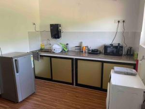 a kitchen with a counter with a microwave and a refrigerator at Studio apartment in Cancaona in Canacona