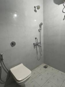 a white bathroom with a toilet and a shower at Studio apartment in Cancaona in Canacona
